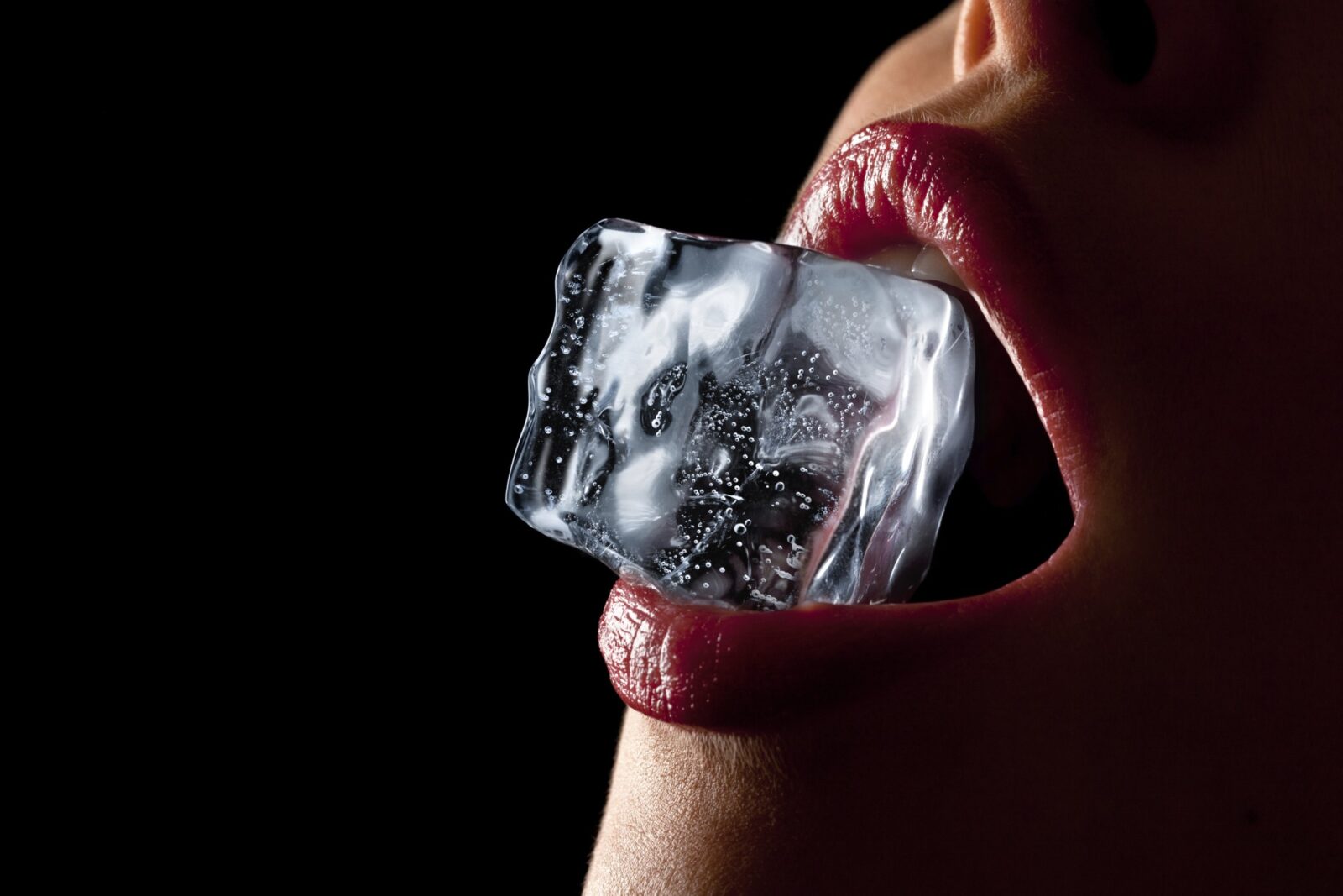 Кубик льда во рту (картинка, как девушка держит зубами кубик льда)